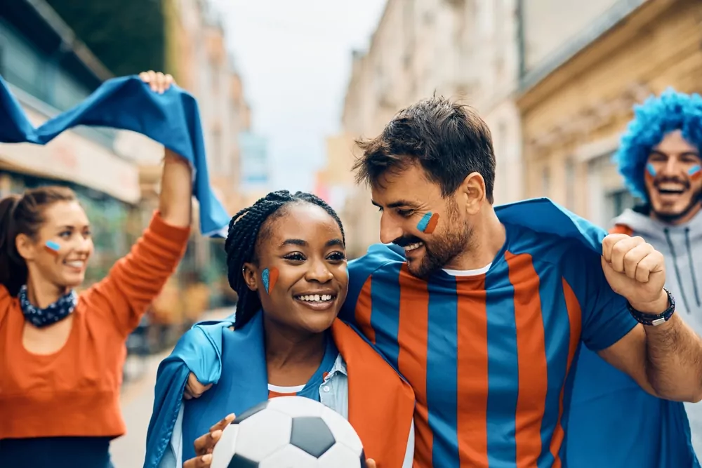 3 young diverse sports fans in street, orange and blue