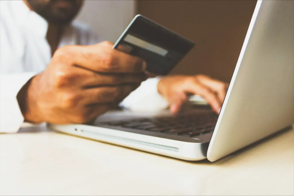 Man holding credit card, with computer, responsible gaming